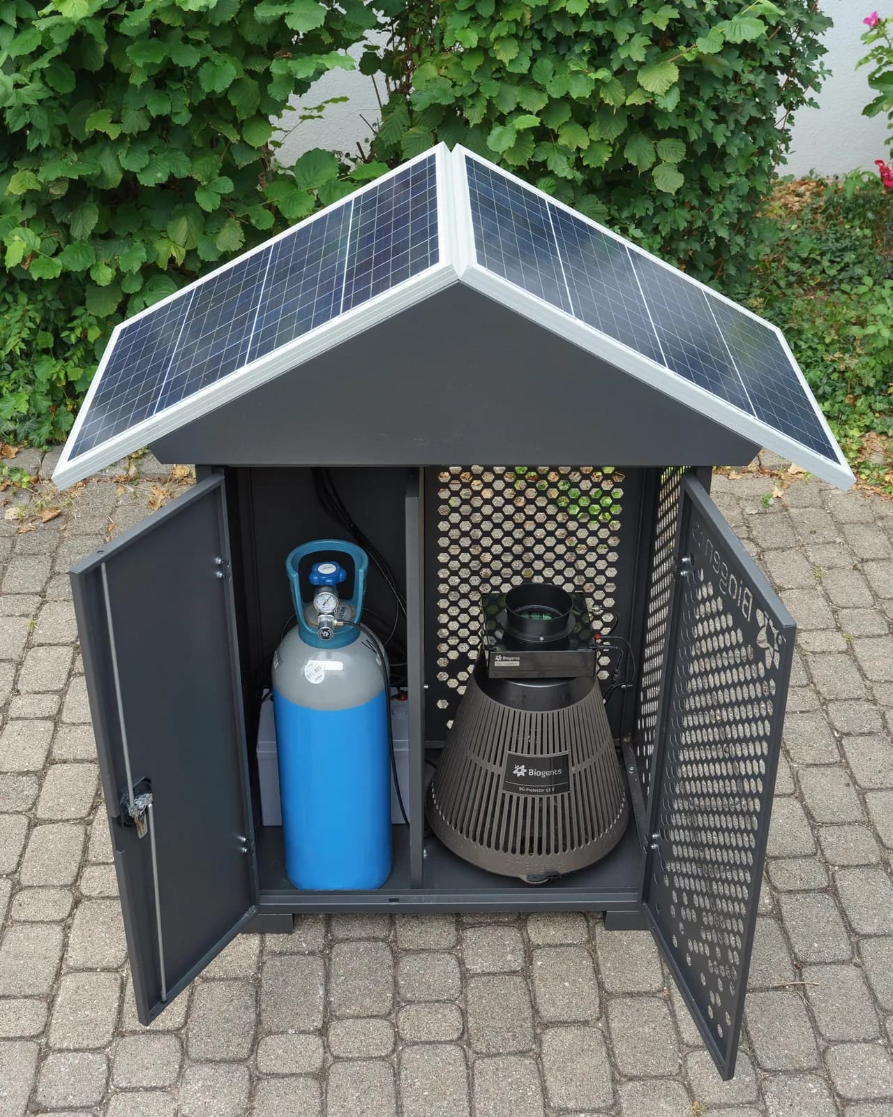 Caisson technique extérieur ouvert, abritant une bouteille de dioxyde de carbone et un piège, sous une toiture inclinée