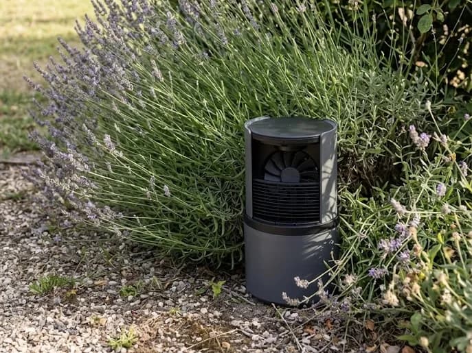 Borne anti-moustiques posée en périphérie du jardin, au pied d'un massif de lavande et de rosiers, à distance de l'aire de jeux